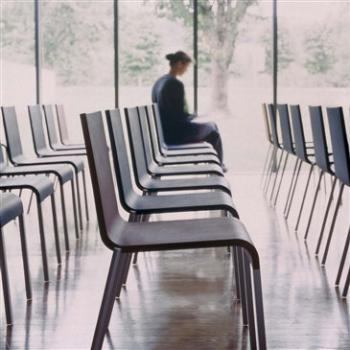 Lady sitting on row of 03 chairs developed for Vitra by Maarten Van Severen