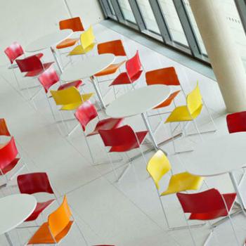 Room with yellow, orange and red 40/4 conference chairs and white tables