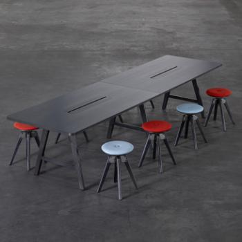 Large A-series table with black stain surrounded by colour chairs